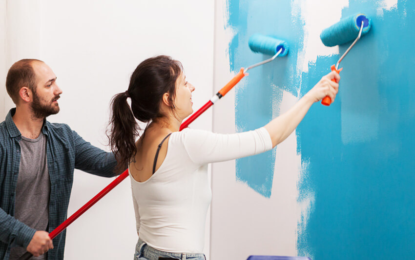 young-couple-painting-the-wall-7WH22K4
